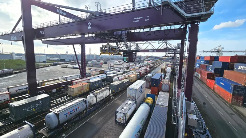 Portalkran über Ganzzügen mit Containern und Tankcontainern an einem KV-Terminal